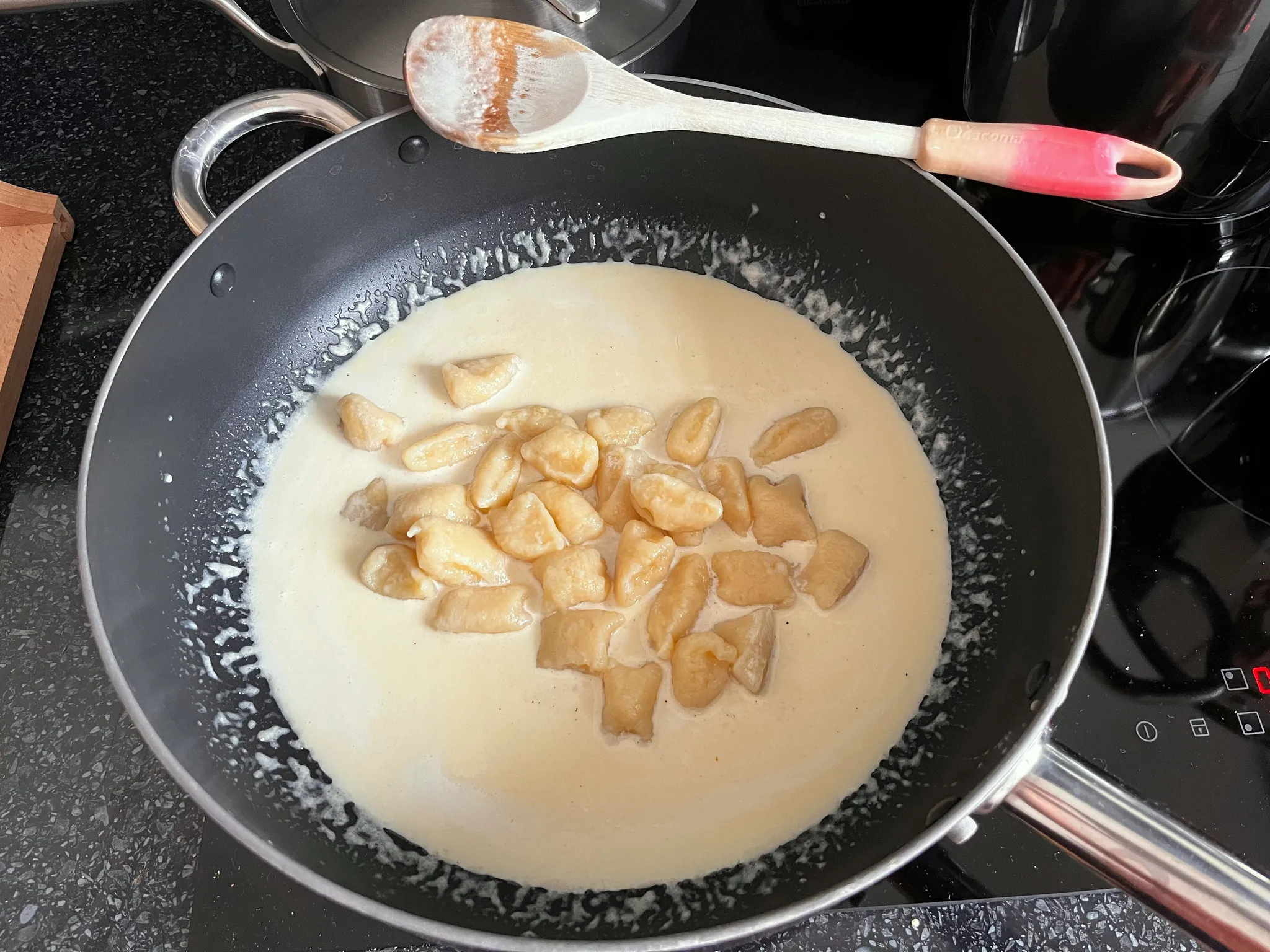 Domácí bramborové noky obalené v krémové omáčce Grana Padano v široké pánvi