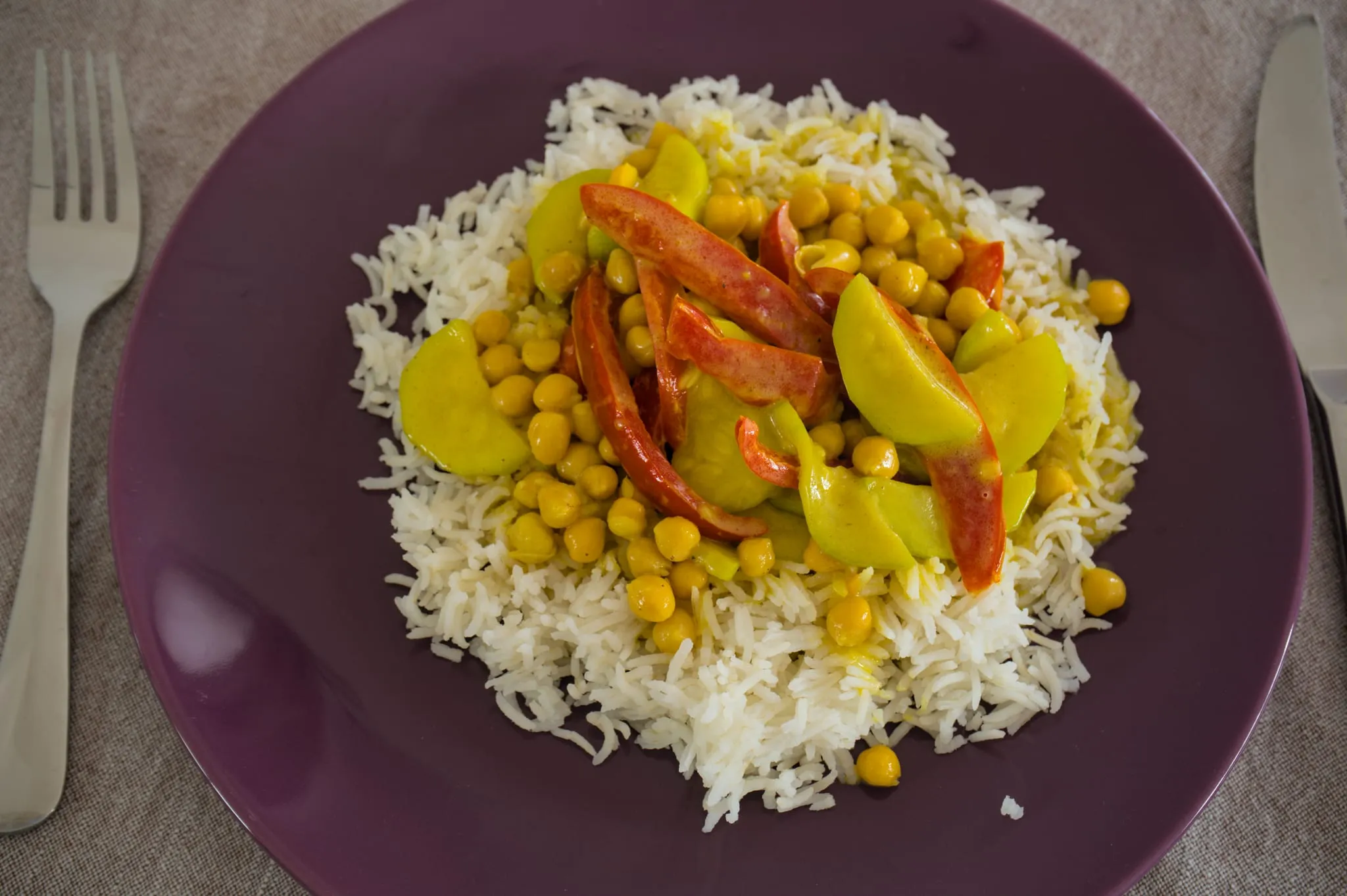 Vegetarian coconut zucchini and chickpea curry with red pepper served over white rice