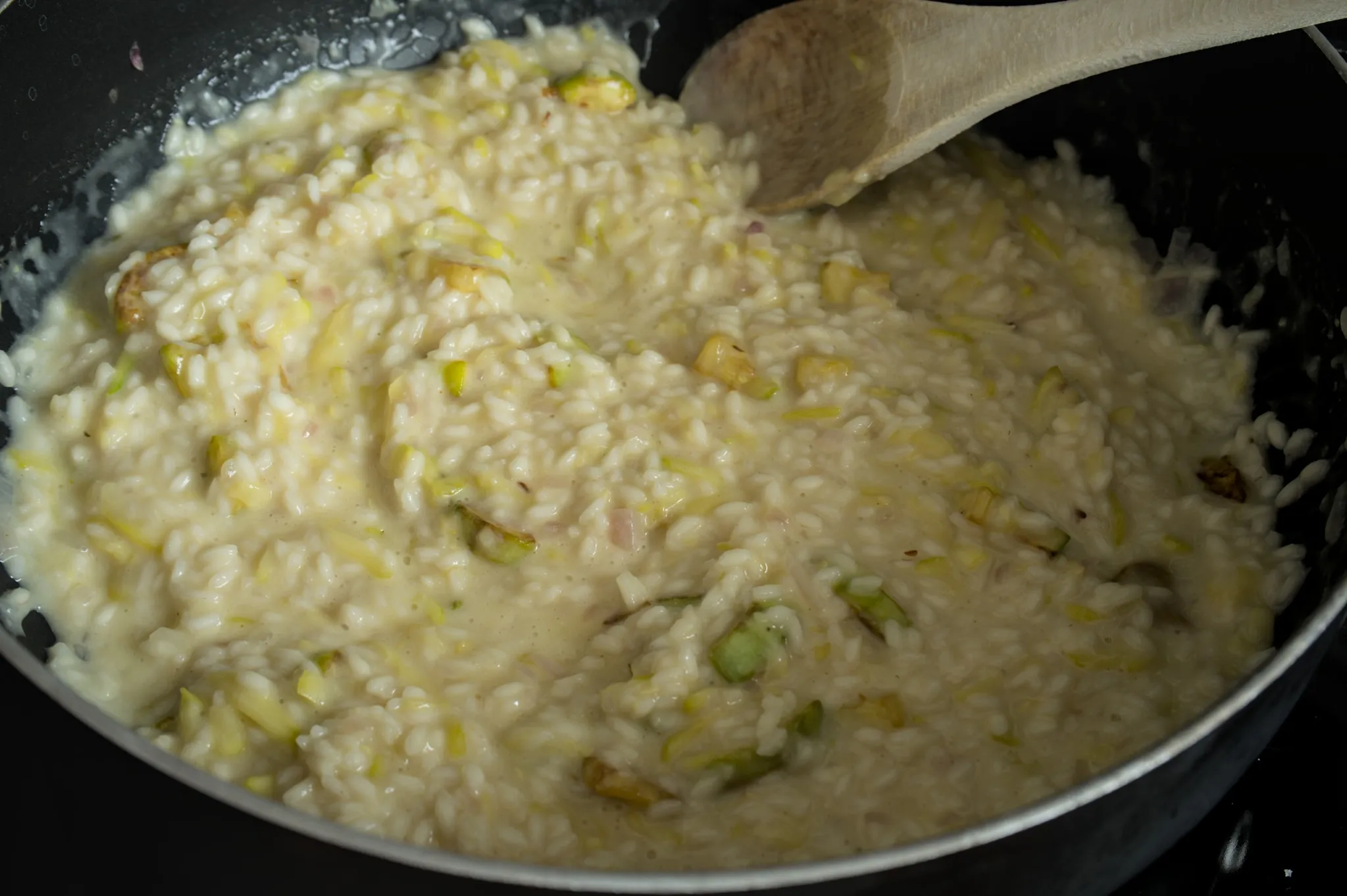 Finished creamy zucchini risotto in a pan with browned zucchini pieces