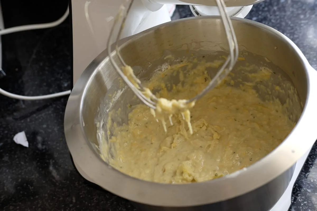 Medium-thick potato and zucchini fritter batter in a mixing bowl