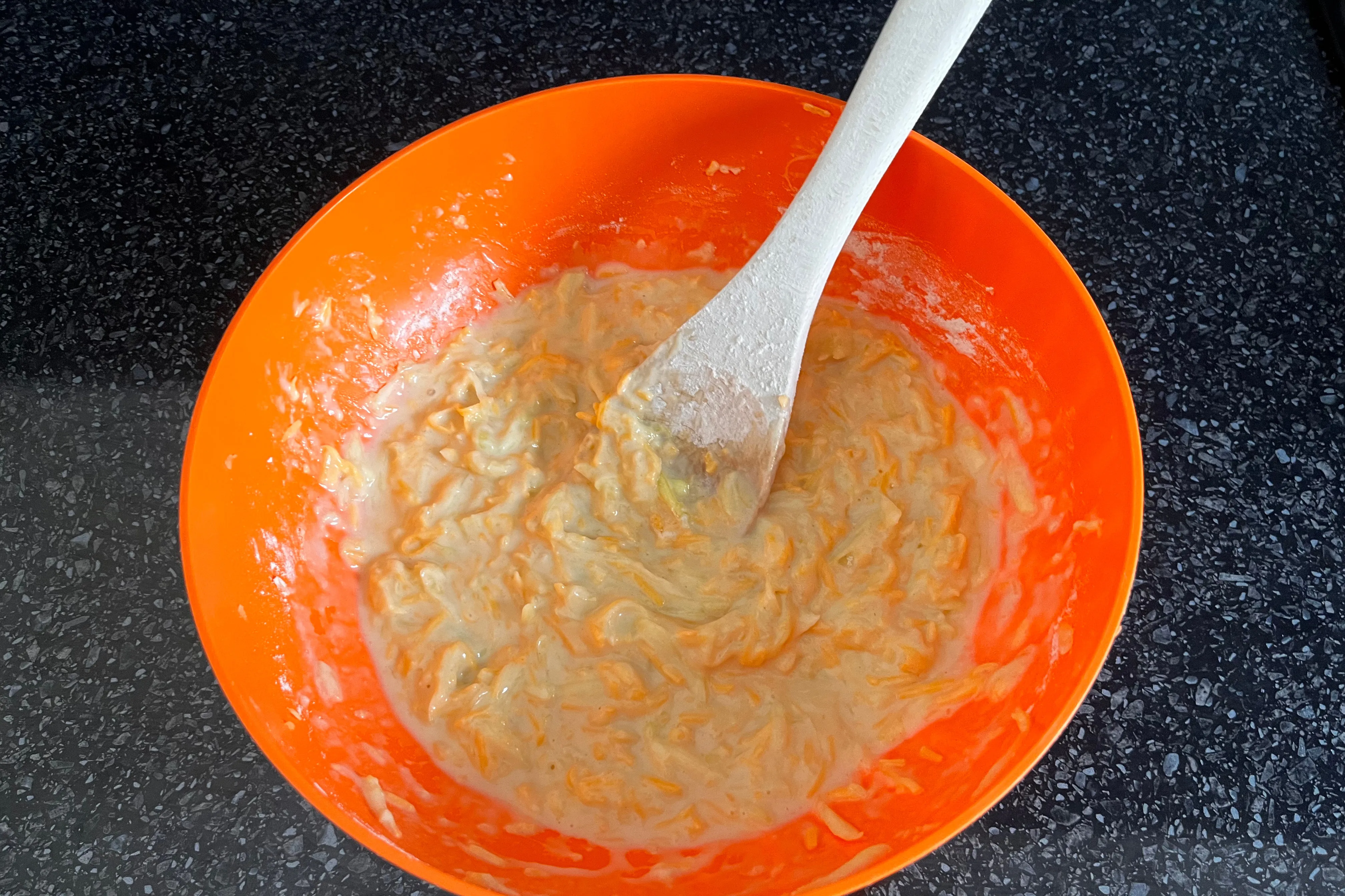 Combined zucchini and Cheddar muffin batter in a mixing bowl