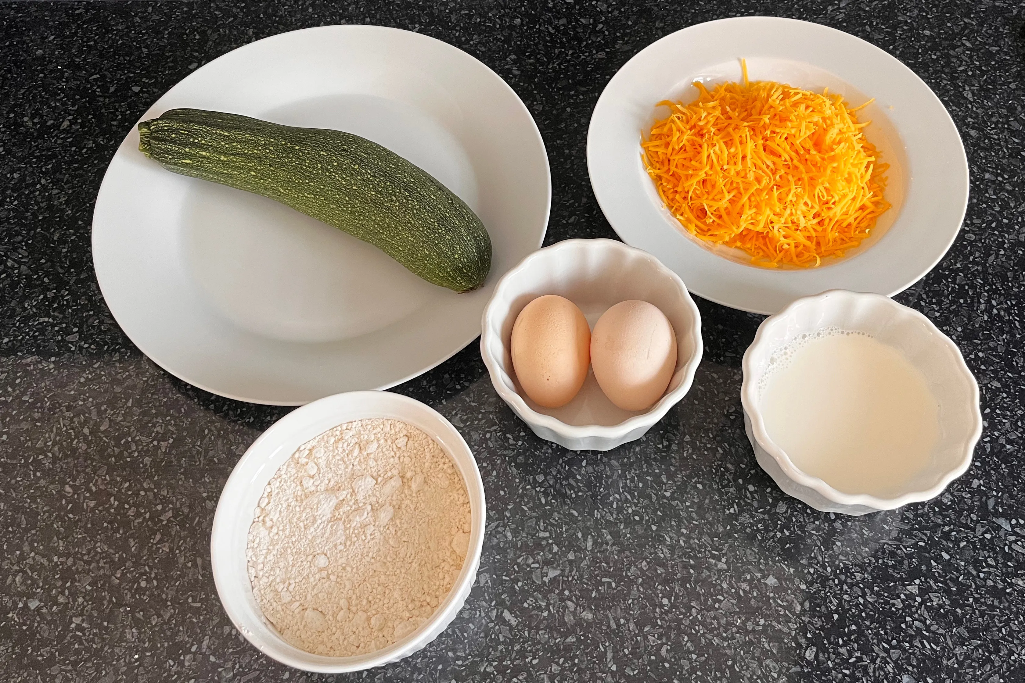 Zucchini, grated Cheddar, eggs, flour and milk prepared for savoury muffins