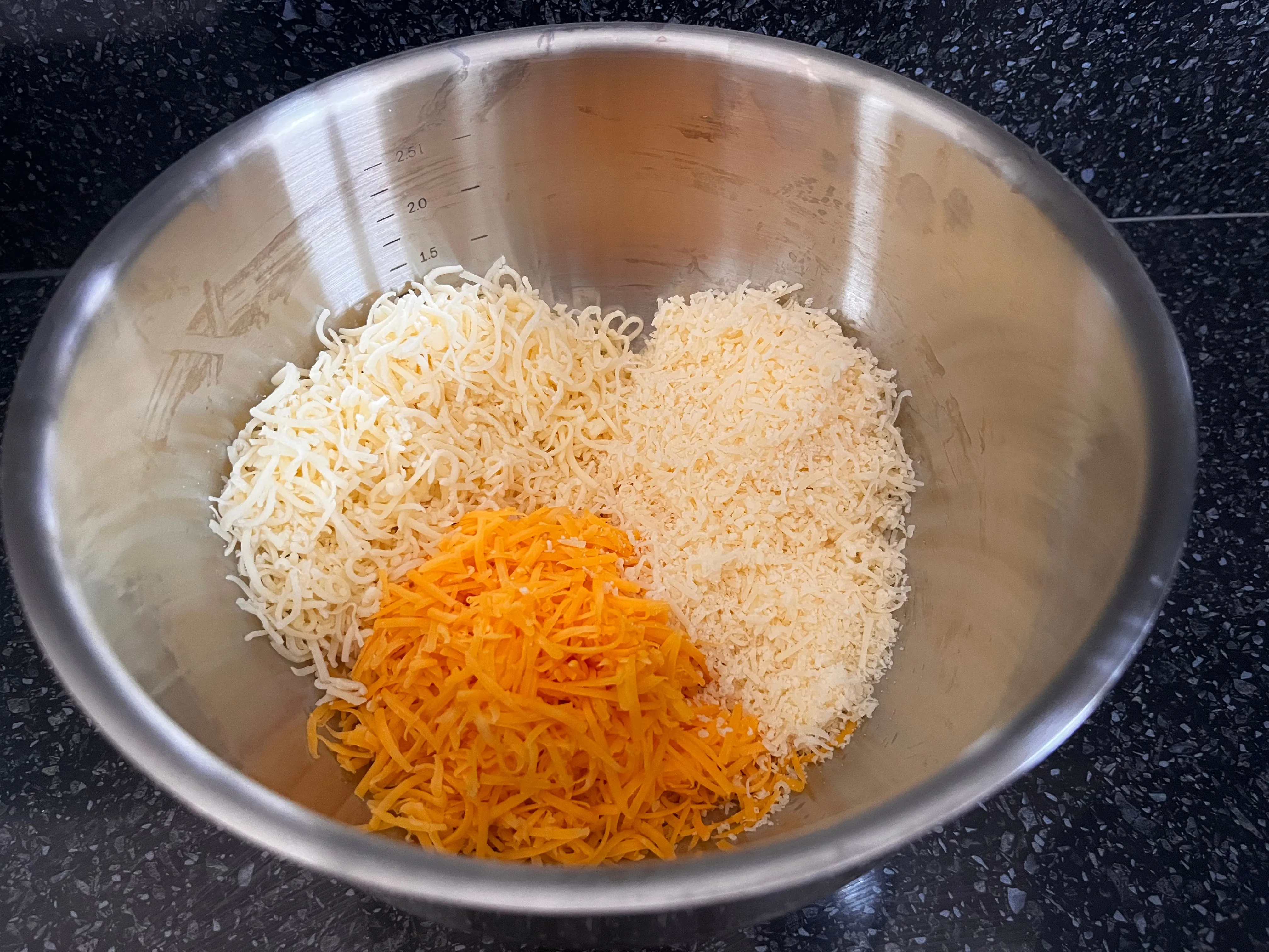Three kinds of grated cheese in a bowl for three-cheese macaroni